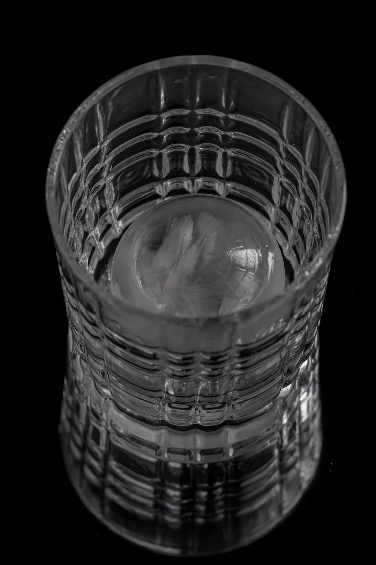 Modernes Whiskeyglas mit strukturiertem Design vor minimalistischer Verpackung mit Cool Glass Logo
