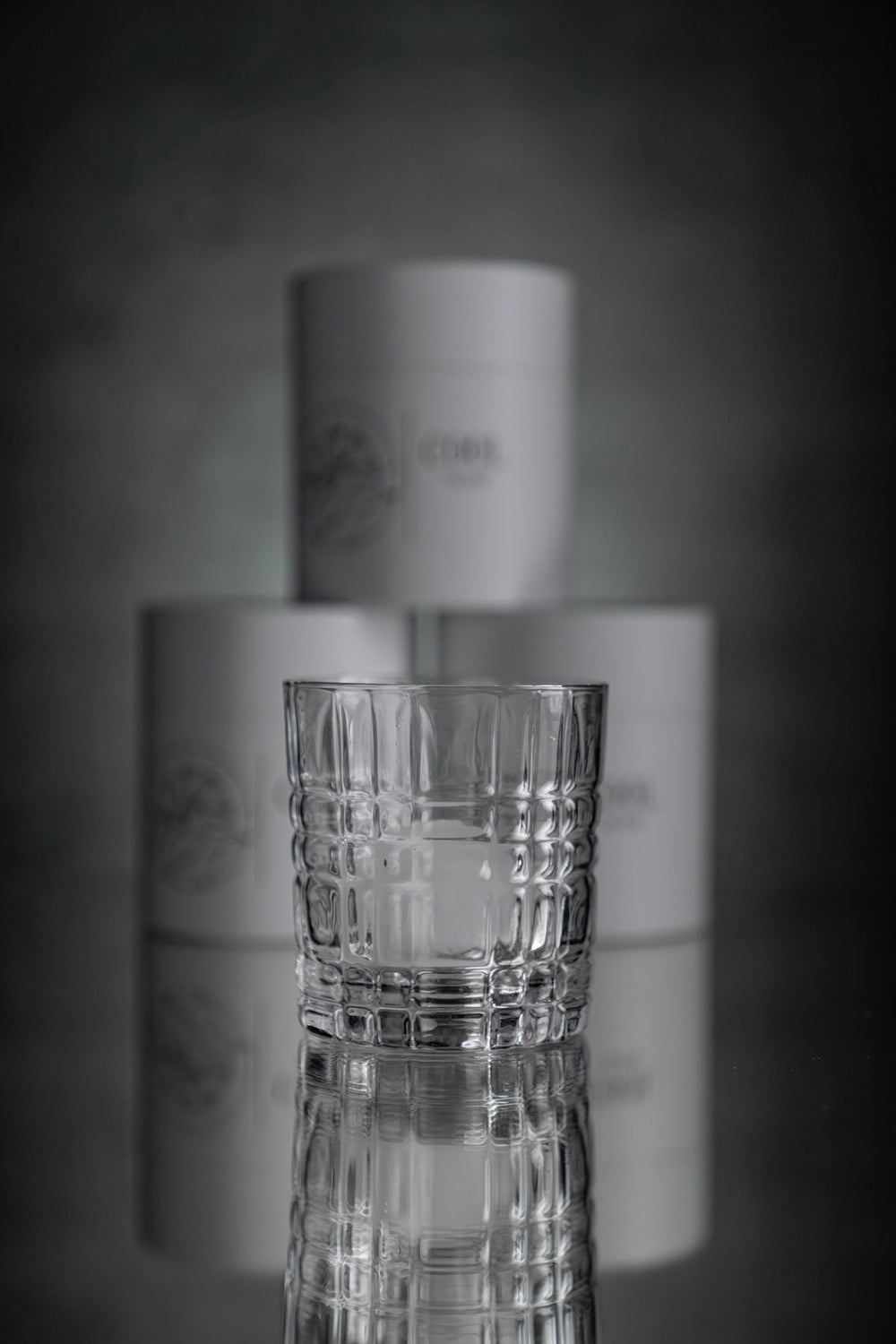 Modernes Whiskeyglas mit strukturiertem Design vor minimalistischer Verpackung mit Cool Glass Logo