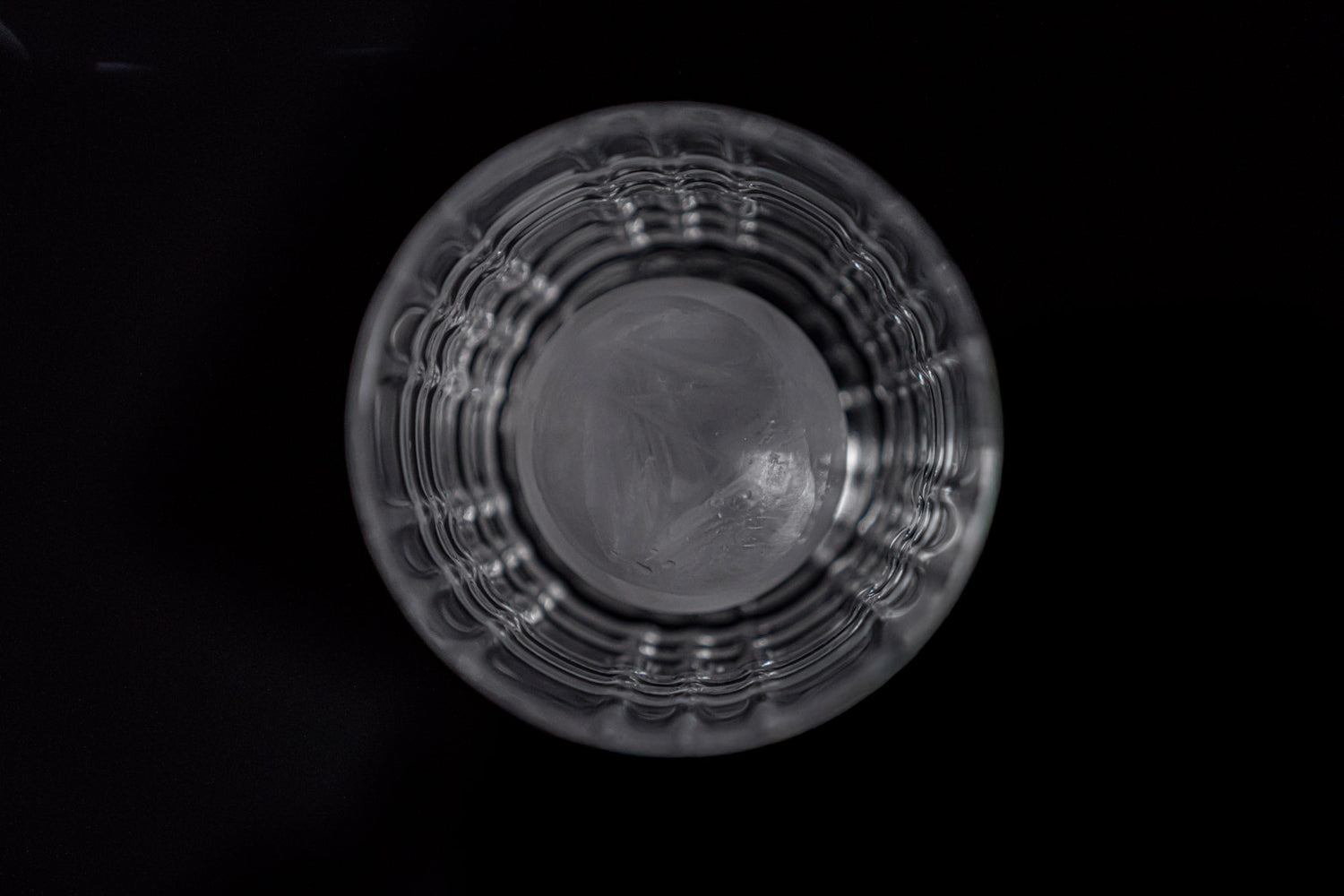 Modernes Whiskeyglas mit strukturiertem Design vor minimalistischer Verpackung mit Cool Glass Logo